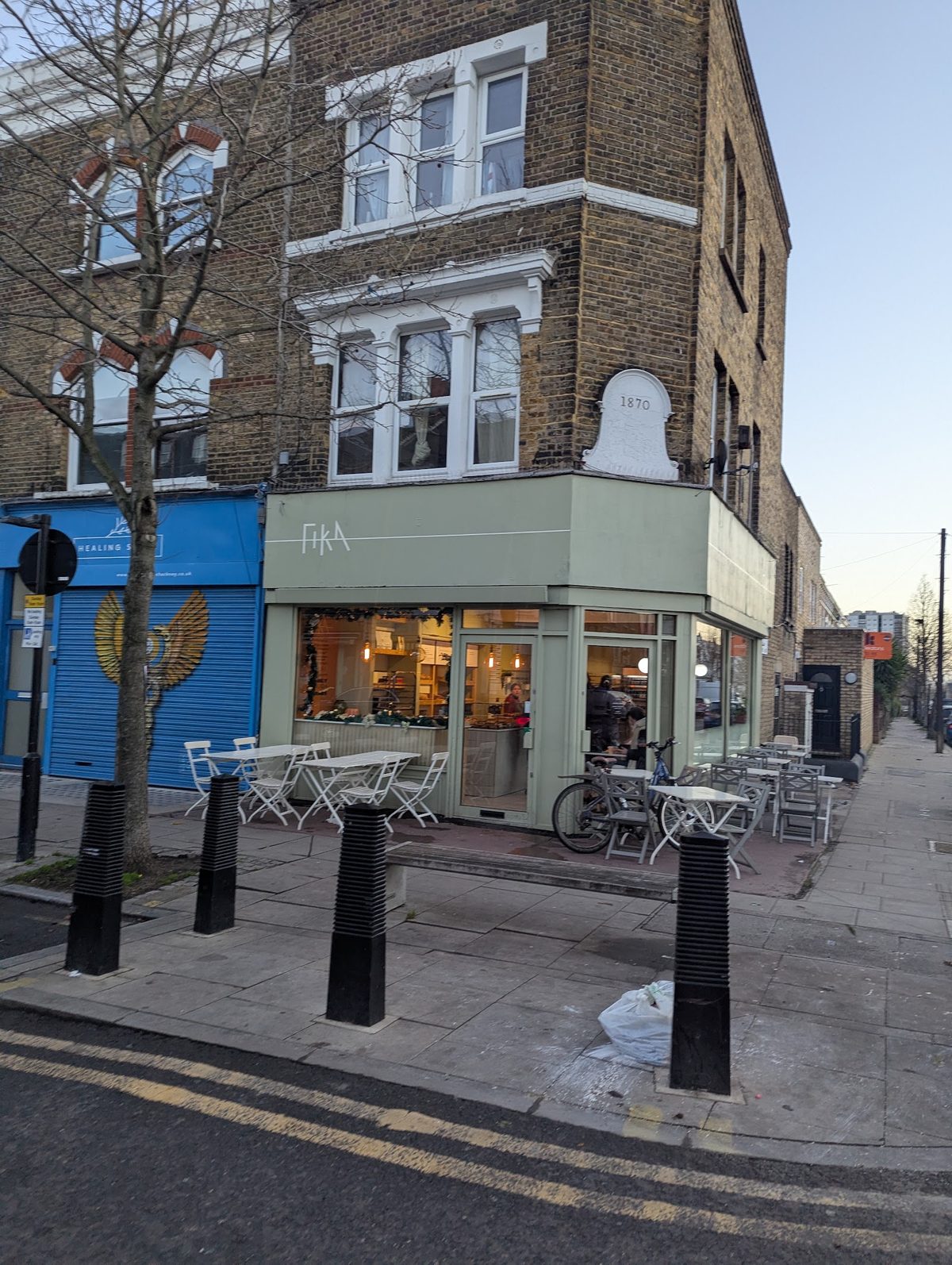 Fika's sage-green corner shopfront on Chatsworth Road, Lower Clapton, with pavement tables